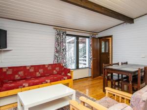 uma sala de estar com um sofá vermelho e uma mesa em Holiday Home Hiekkasaari by Interhome em Juhanala