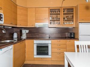 eine Küche mit Holzschränken und einem Backofen in der Unterkunft Holiday Home Ylläs-eeli green house c1 by Interhome in Ylläsjärvi