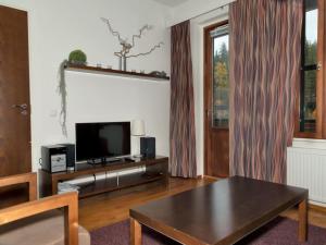 a living room with a tv and a table at Holiday Home Ylläs chalet 3508 by Interhome in Ylläs