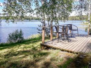 JuhanalaにあるHoliday Home Rantala by Interhomeの湖畔の木製の遊歩道(テーブル、椅子付)