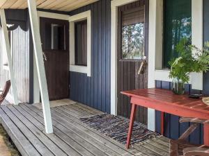 um alpendre de uma casa com uma mesa e uma janela em Holiday Home Rantala by Interhome em Juhanala