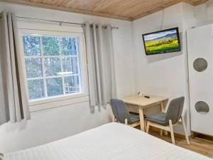 1 dormitorio con mesa, 2 sillas y ventana en Holiday Home Weekend duo by Interhome en Lahdenperä
