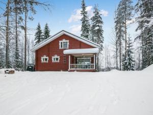 Juhanala的住宿－瓦特拉卡維洛瑪克斯庫度假屋，雪中小红房子,有树