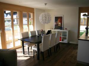 uma sala de jantar com uma mesa preta e cadeiras brancas em Apartment Mühleport 1 by Interhome em Adelboden