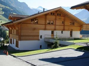 a large wooden house with a lot of windows at Apartment Mühleport 1 by Interhome in Adelboden