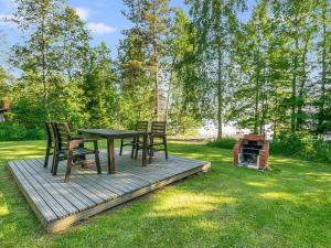 un tavolo e delle sedie su un ponte di legno nell'erba di Holiday Home Laavusranta by Interhome a Kantala