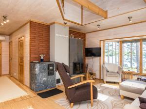 Una sala de estar con una silla y una chimenea. en Holiday Home Kuvalanranta by Interhome, en Mouhu