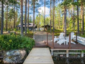 un puente de madera con dos bancos y un mirador en Holiday Home Kuvalanranta by Interhome, en Mouhu