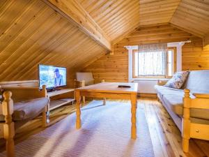 een woonkamer met een bank, een tafel en een tv bij Holiday Home Mäntykumpu by Interhome in Petäjävesi
