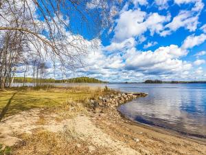 a view of a lake with a rock wall at Holiday Home Beach 2 - 5664 by Interhome in Vääksy