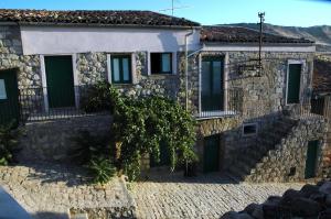 a stone house with a tree in front of it at Case Eleutheria in Petralia Soprana