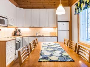 アカスロンポロにあるHoliday Home Aamutähti by Interhomeのキッチン(木製テーブル、椅子、テーブルクロス付)