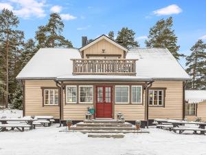 een huis met een rode deur in de sneeuw bij Holiday Home Päätalo by Interhome in Vääksy