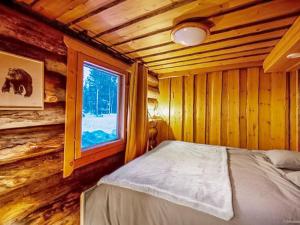 una camera con letto e finestra in una baita di tronchi di Holiday Home Kelosaajo by Interhome a Raattama
