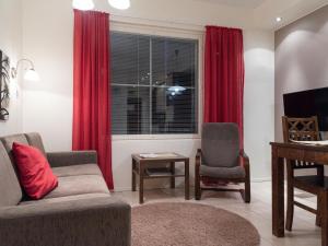 sala de estar con sofá y ventana con cortinas rojas en Holiday Home Yllästar 3 as 502 by Interhome, en Äkäslompolo