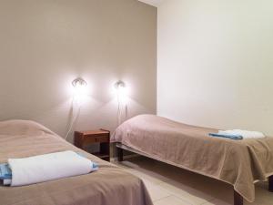 a room with two beds and two lights on the wall at Holiday Home Yllästar 3 as 502 by Interhome in Äkäslompolo +8 photos