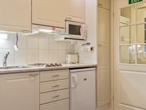 アカスロンポロにあるHoliday Home Yllästar 1 as 202 by Interhomeの白いキャビネット、シンク、電子レンジ付きのキッチンが備わります。