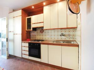 フォルテ・デイ・マルミにあるApartment Gelsomino by Interhomeの白いキャビネットとシンク付きのキッチン