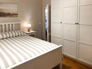 a bedroom with a large bed and white cabinets at Apartment Gelsomino by Interhome in Forte dei Marmi