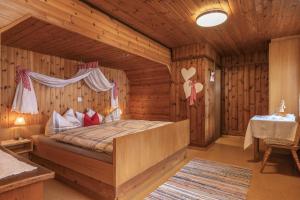 um quarto com uma cama num chalé de madeira em Pension Bauernhof Stanahof em Fresach