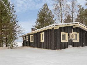 um pequeno prédio preto na neve com árvores em Holiday Home Inninniemi by Interhome em Pyhäsalmi