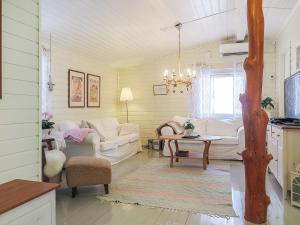 uma sala de estar com mobiliário branco e uma árvore em Holiday Home Inninniemi by Interhome em Pyhäsalmi mais 20 fotografias