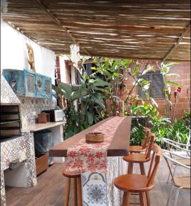 a patio with a table and some chairs and a table and a tableablish at Ganesh Chalés in Boracéia