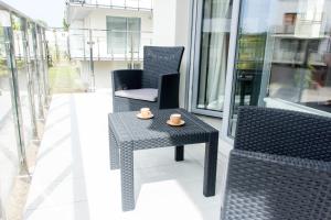 a table and two chairs on a balcony at Komfortowy Apartament Lazur z garażem in Kołobrzeg