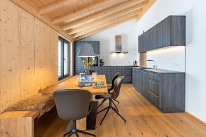a kitchen with wooden cabinets and a table and chairs at Chalet Allgäublick in Sonthofen
