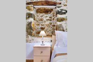 - une chambre avec un lit et une lampe sur une table de chevet dans l'établissement Maria's cozy stonehouse, à Kerames