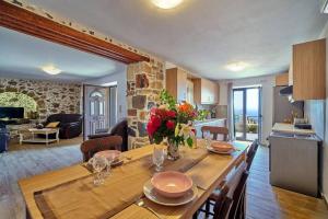 a kitchen and living room with a table with flowers on it at Maria's cozy stonehouse in Kerames +32 photos