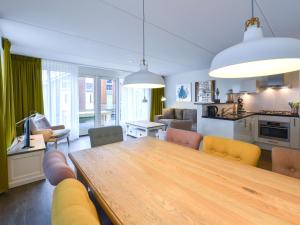uma cozinha e sala de jantar com uma mesa de madeira e cadeiras em Holiday Home De Meerparel-1 by Interhome em Uitgeest