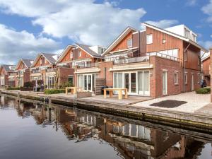 uma fila de casas ao lado de uma massa de água em Holiday Home De Meerparel-1 by Interhome em Uitgeest