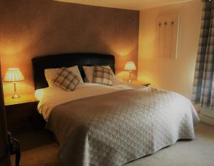 a bedroom with a large bed with two lamps at The Kings Head in Louth