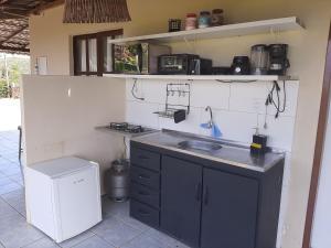 a small kitchen with a sink and a stove at Casa do caia in Fernando de Noronha