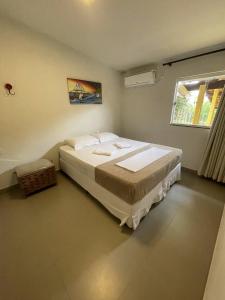 ein Schlafzimmer mit einem großen Bett in einem Zimmer mit einem Fenster in der Unterkunft Casarão Hostel in Capitólio