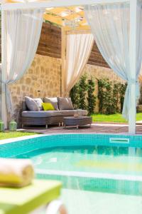 salon z kanapą i basenem w obiekcie Villa Green Mare w mieście Prínos
