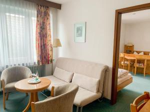 a living room with a couch and a table at Landhotel Bauernschmitt in Pottenstein