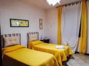 2 camas en una habitación con sábanas amarillas en Terre Di Gratia, en Camporeale