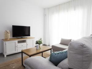 a living room with a couch and a tv at La Fontanilla Place in Conil de la Frontera