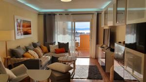 un soggiorno con divano e TV di Apartamento FORTUNA La Manga a La Manga del Mar Menor