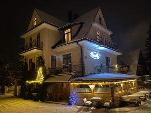 Um edifício com luzes de Natal à frente. em Rusałka em Zakopane