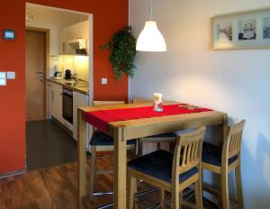 una cucina con tavolo in legno e panno rosso di Strandhotel S33-213 a Heiligenhafen
