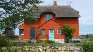 una casa arancione con tetto di paglia di Strandhotel S33-213 a Heiligenhafen