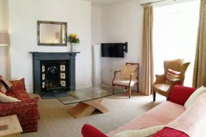 ein Wohnzimmer mit einem Glastisch und einem Kamin in der Unterkunft Cornwall, Looe - Magical Pendriffey in Pelynt