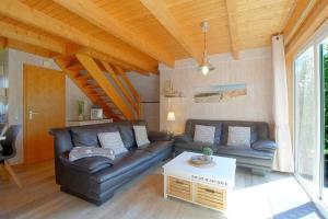 a living room with a leather couch and a table at SR VS1 Haus Ellie in Dorum-Neufeld