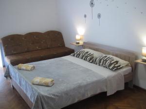 a bedroom with a bed with two pillows and a couch at Apartment Rota in Zadar