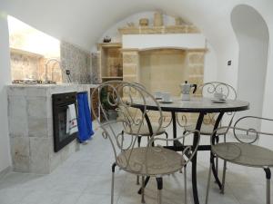 a table and chairs in a kitchen with a stove at Dimora dell'Isola Gallipoli in Gallipoli