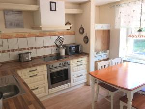 a kitchen with a table and a stove top oven at Ferienwohnung Kalldorf in Kalletal