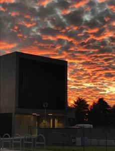 a building with a cloudy sky at sunset at Bv hotel in Brignano Gera dʼAdda